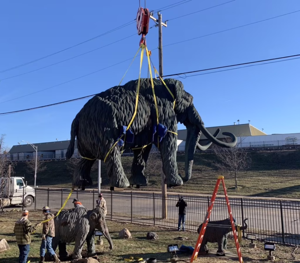 Cranes Lift Wooly Mammoth Statues